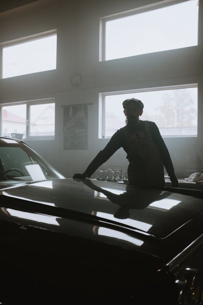 Man in Black Jacket Standing Beside Black Car